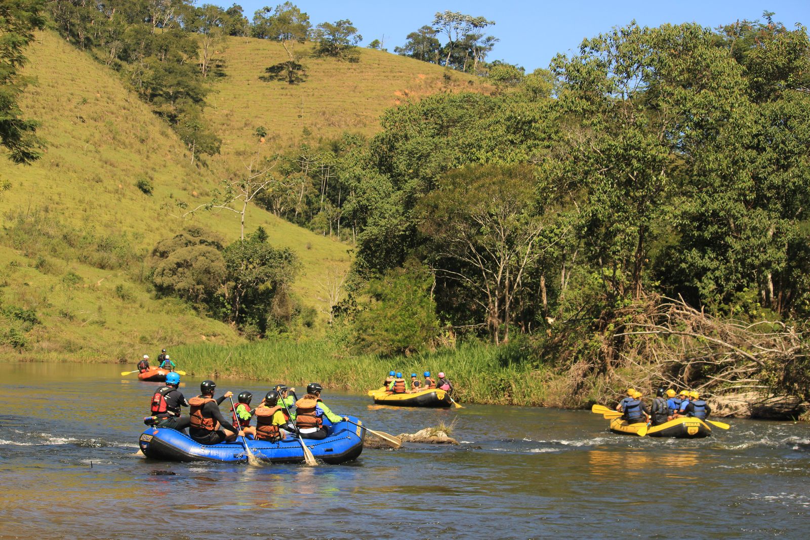 Botes da Montana remando em trecho calmo do Braz Adão, entre morros verdes e mata
