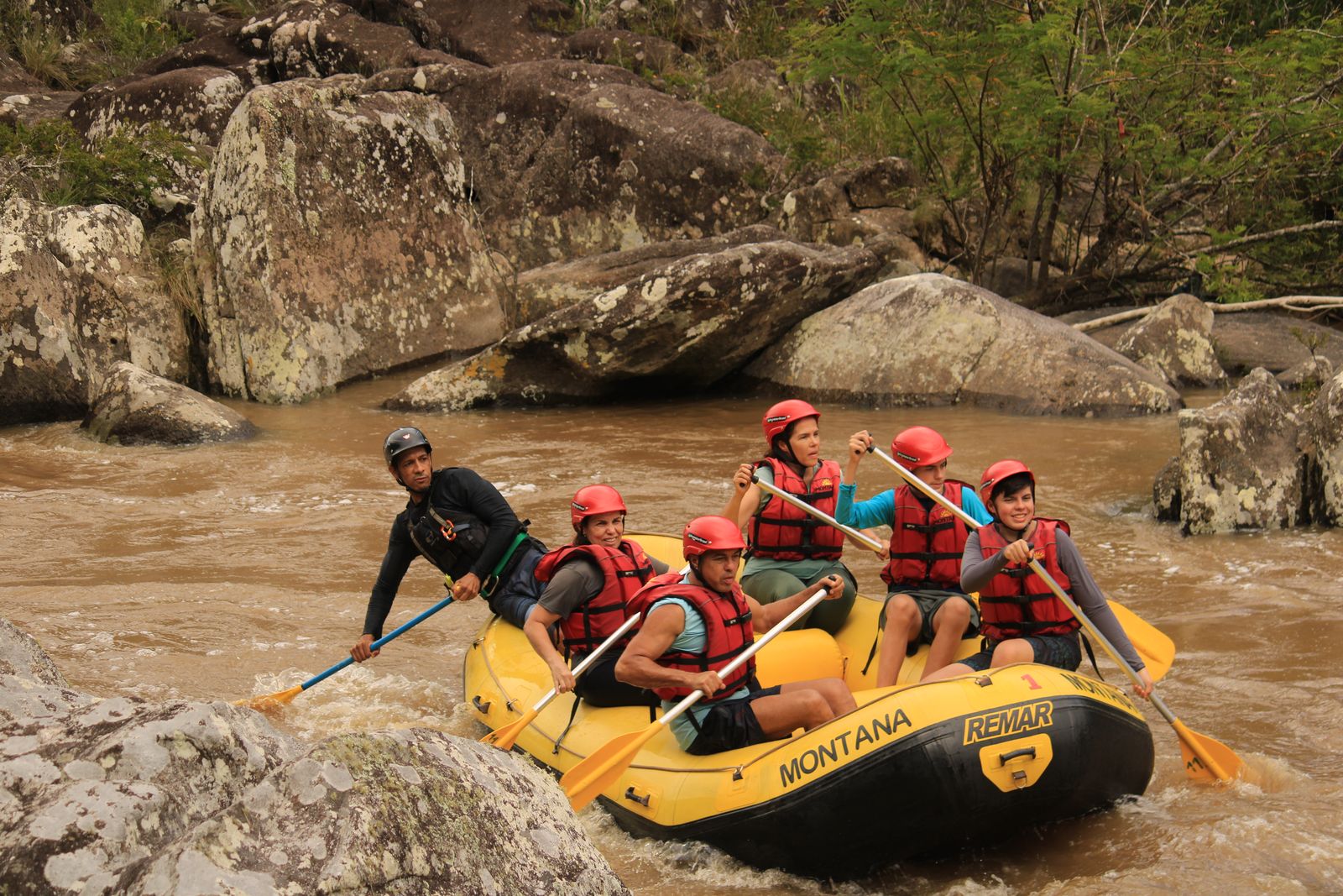 Turma remando no bote amarelo da Montana entre pedras grandes no trecho Palmeiras
