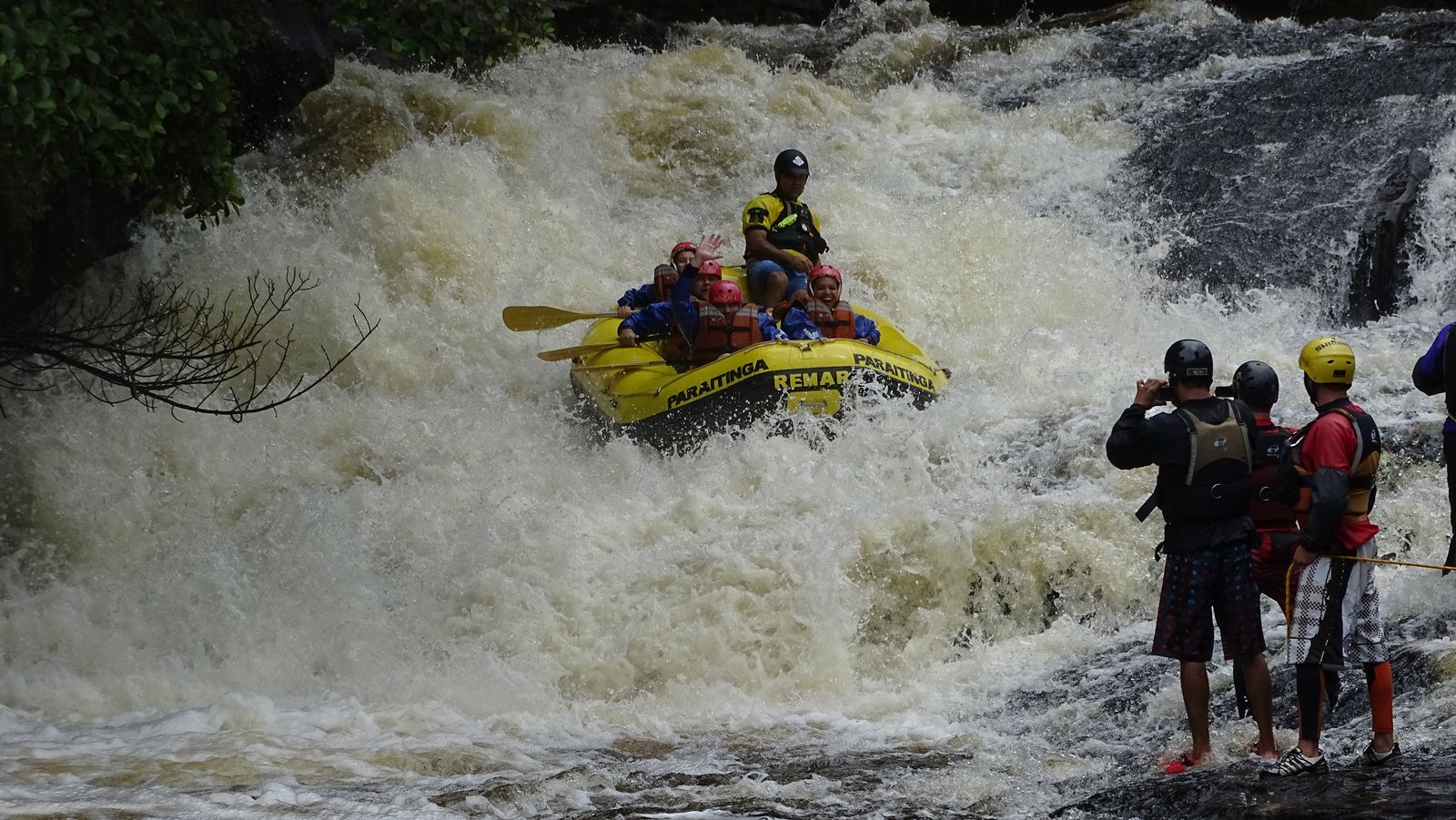 Bote encarando a queda d'água enquanto os guias fotografam da pedra, no Santa Virgínia